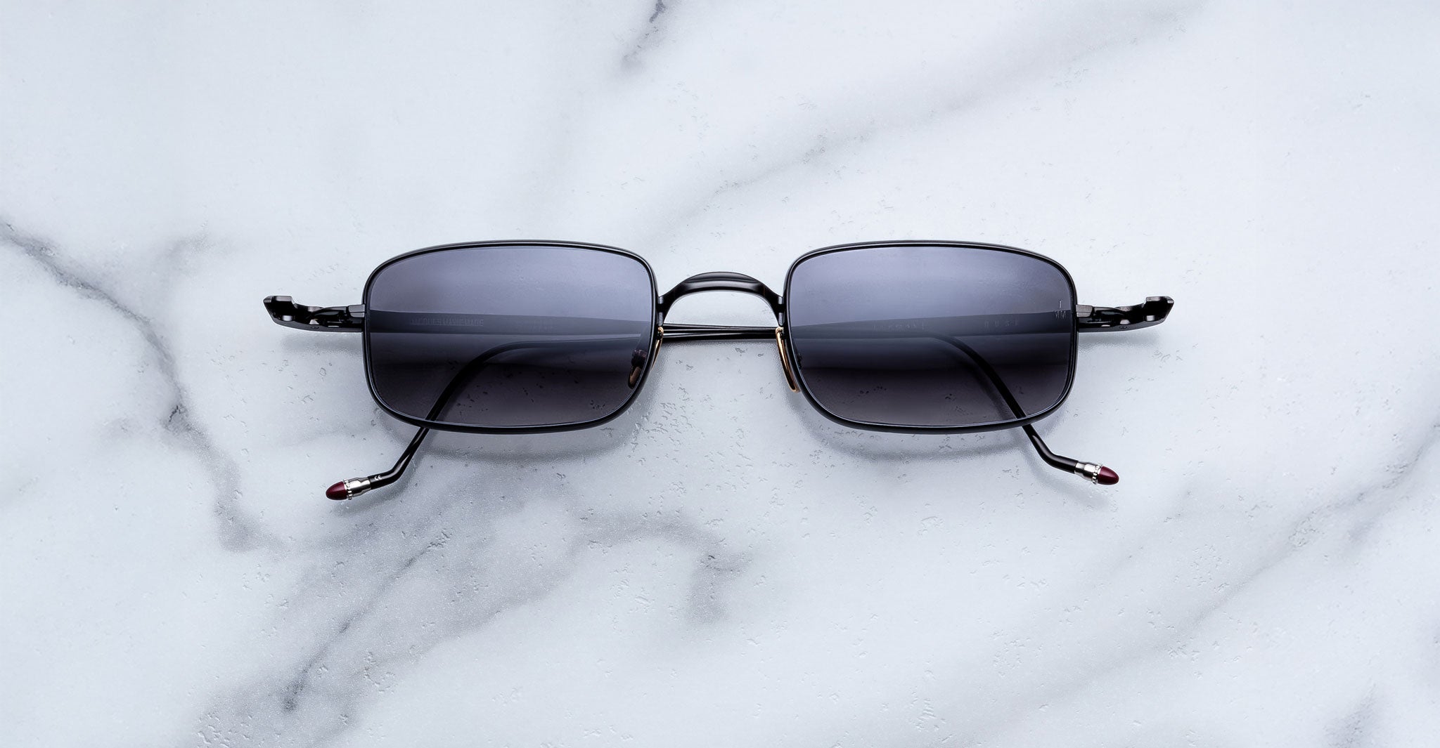 Jacques Marie Mage Dusk black polarized sunglasses with dark lenses, top view.