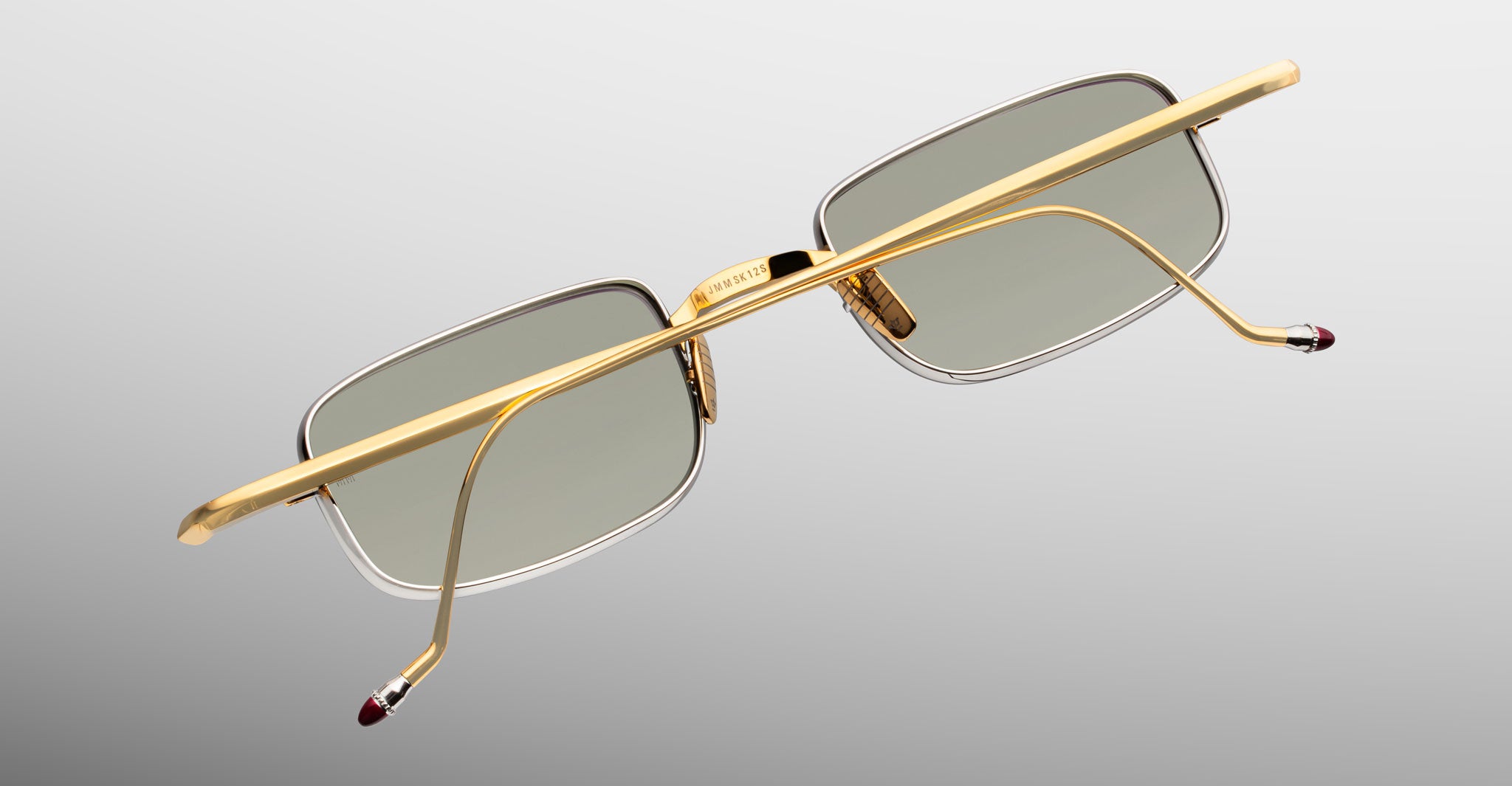 Jacques Marie Mage Dusk gold rectangular sunglasses with gray lenses, viewed from the back.