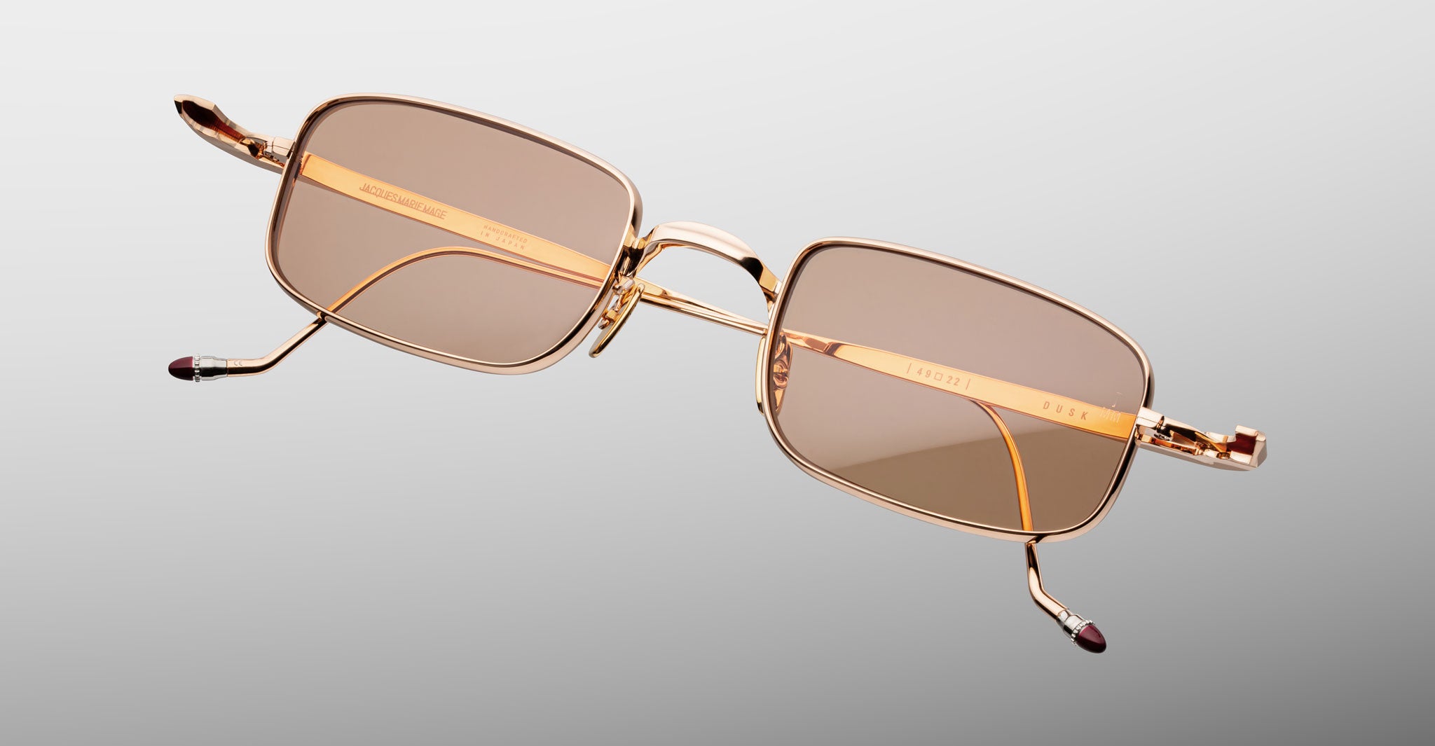 Jacques Marie Mage Dusk sunglasses: gold rectangular frame, brown lenses, shown at an angle.