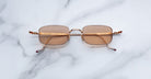 Jacques Marie Mage Dusk sunglasses with gold frames and brown lenses, shown from above.