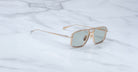 Jacques Marie Mage Earl gold aviator sunglasses with polarized green lenses, viewed from above.