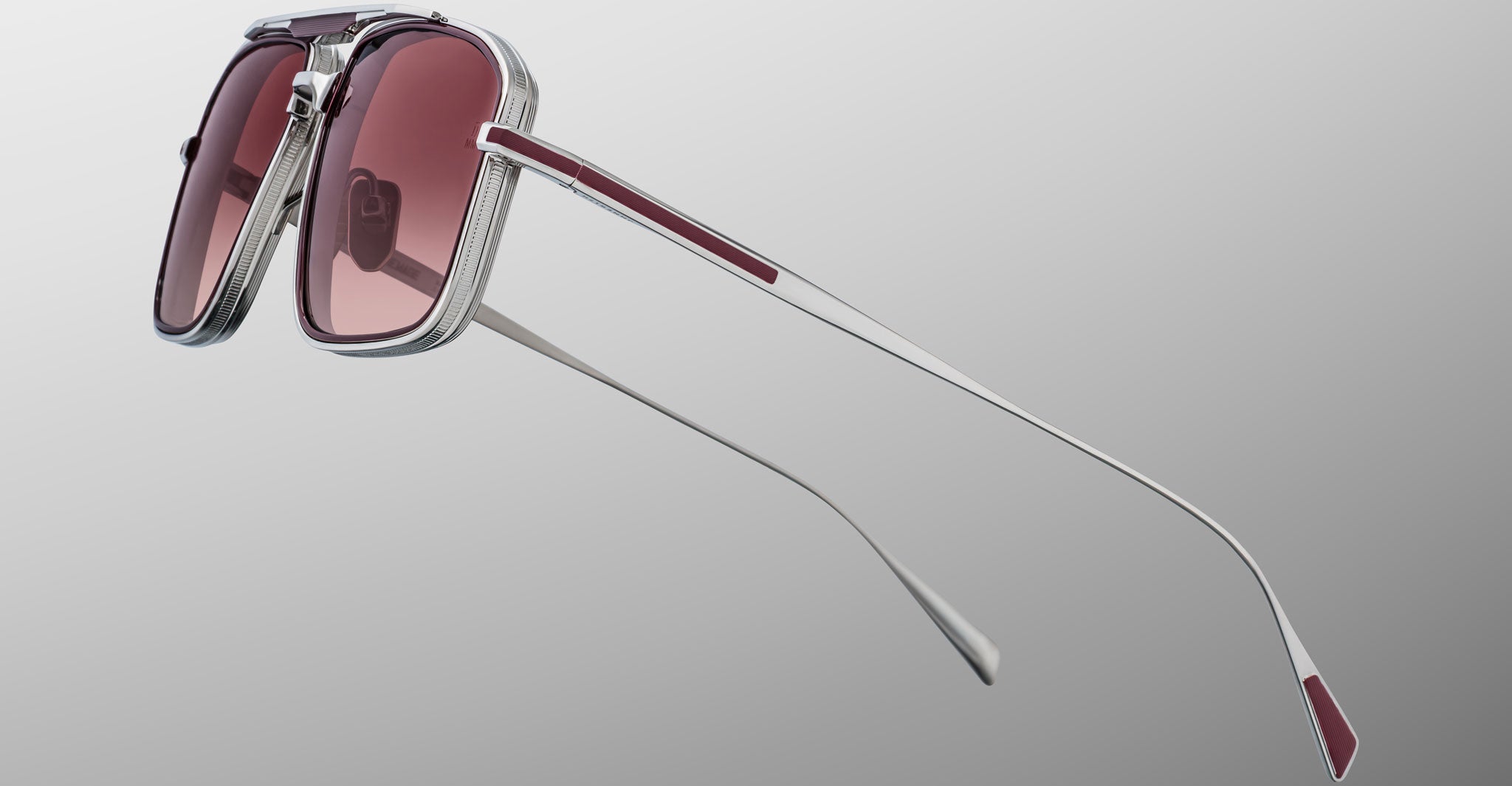 Jacques Marie Mage Earl sunglasses, silver rectangular frame with reddish lenses and white-red temples, shown from a front angle.