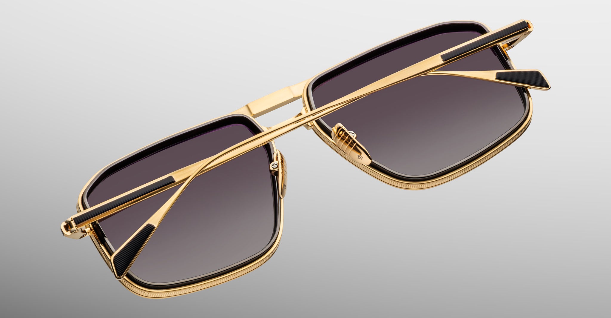 Jacques Marie Mage Earl gold rectangular sunglasses with dark lenses, viewed from an angled top perspective.