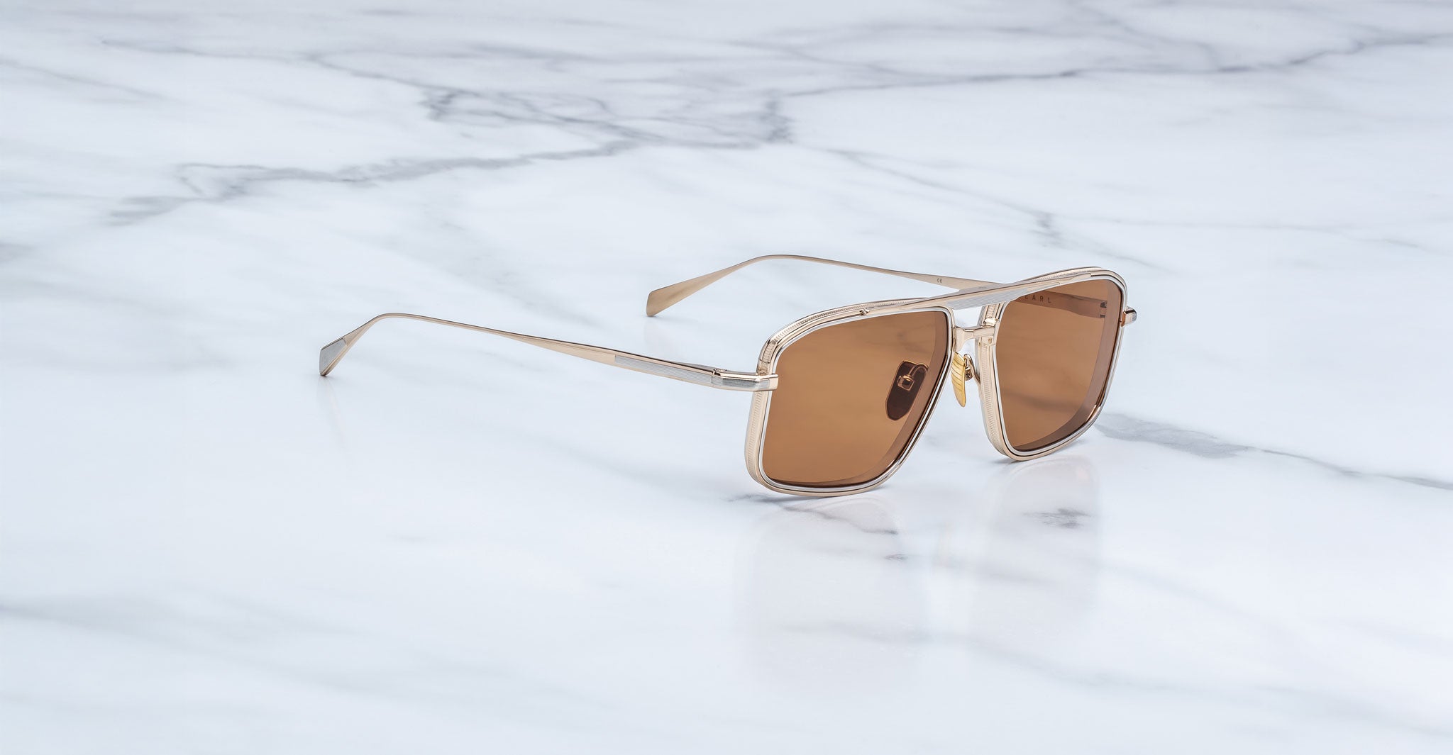 Jacques Marie Mage Earl gold aviator sunglasses with brown lenses, shown from above.
