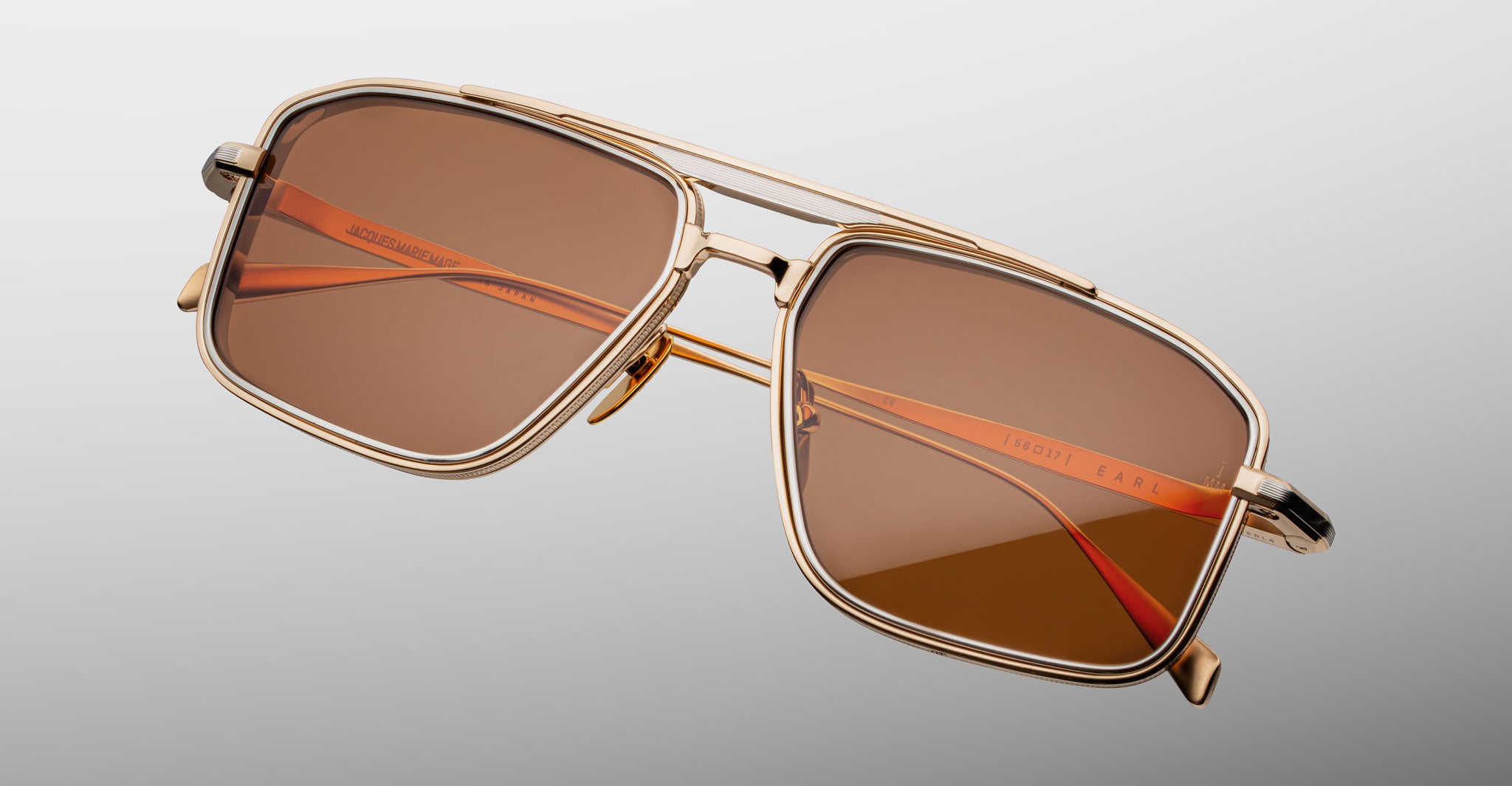 Jacques Marie Mage Earl sunglasses with gold frame, rectangular brown lenses, and orange-tinted arms, front view.