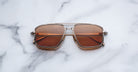 Jacques Marie Mage Earl aviator sunglasses with brown lenses and gold frames, shown from above.