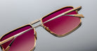 Close-up of Jacques Marie Mage Earl sunglasses, gold frame, rectangular gradient pink lenses, viewed from the front.