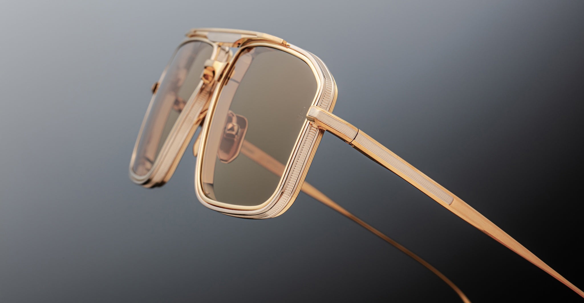 Close-up of Jacques Marie Mage Earl square sunglasses featuring gold frames and brown lenses, viewed from the front.