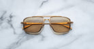 Jacques Marie Mage Earl aviator sunglasses with gold frames and brown lenses, top view.