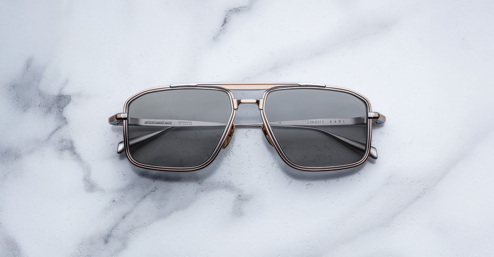 Jacques Marie Mage Earl aviator sunglasses with dark lenses, viewed from above, product on display.