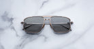 Jacques Marie Mage Earl aviator sunglasses with dark lenses, viewed from above, product on display.
