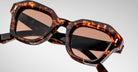Detailed front view of a pair of Jacques Marie Mage Eichler Havana, thick-framed sunglasses with brown lenses on a plain background