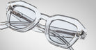 Detailed front view of a pair of Jacques Marie Mage Eichler crystal, thick-framed sunglasses with light grey lenses on a plain background