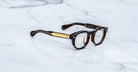 Jacques Marie Mage Eiko round tortoiseshell eyeglasses with gold-accented arms, top-down view.