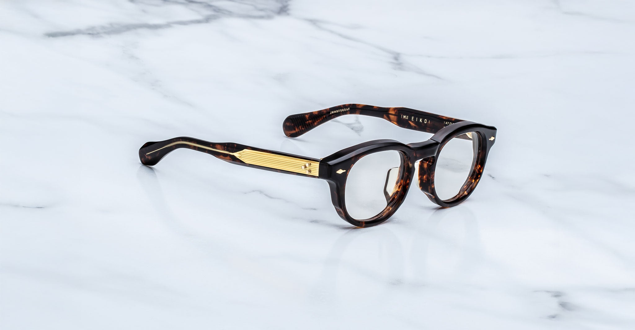 Jacques Marie Mage Eiko round tortoiseshell eyeglasses with gold-accented arms, top-down view.