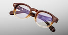 Jacques Marie Mage Eiko eyeglasses, round shape, brown-beige gradient frames, clear lenses, subtle temple branding, front view.