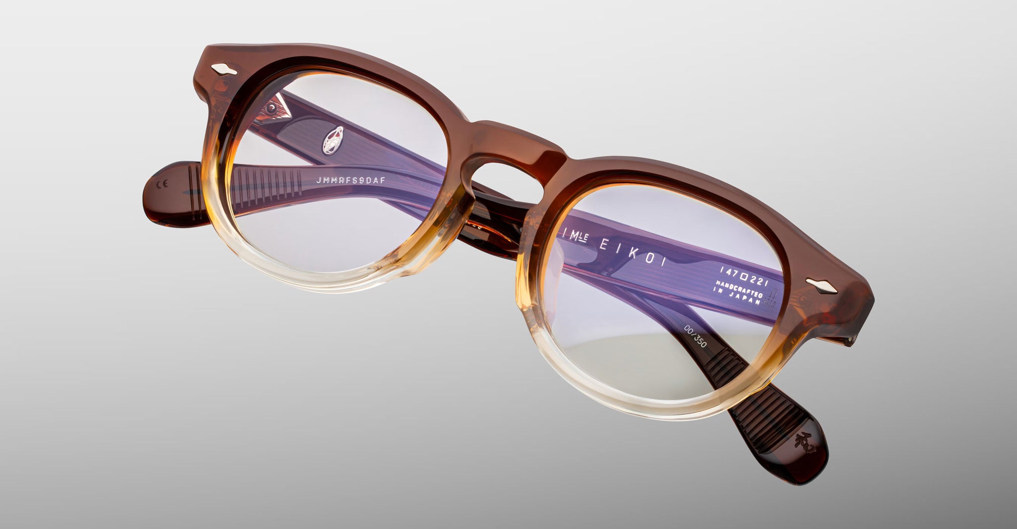 Jacques Marie Mage Eiko eyeglasses, round shape, brown-beige gradient frames, clear lenses, subtle temple branding, front view.