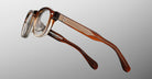 Jacques Marie Mage Eiko round eyeglasses, brown and clear acetate, textured temples, front view.