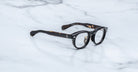 Jacques Marie Mage Eiko round black thick-rimmed eyeglasses, top view, product displayed clearly.