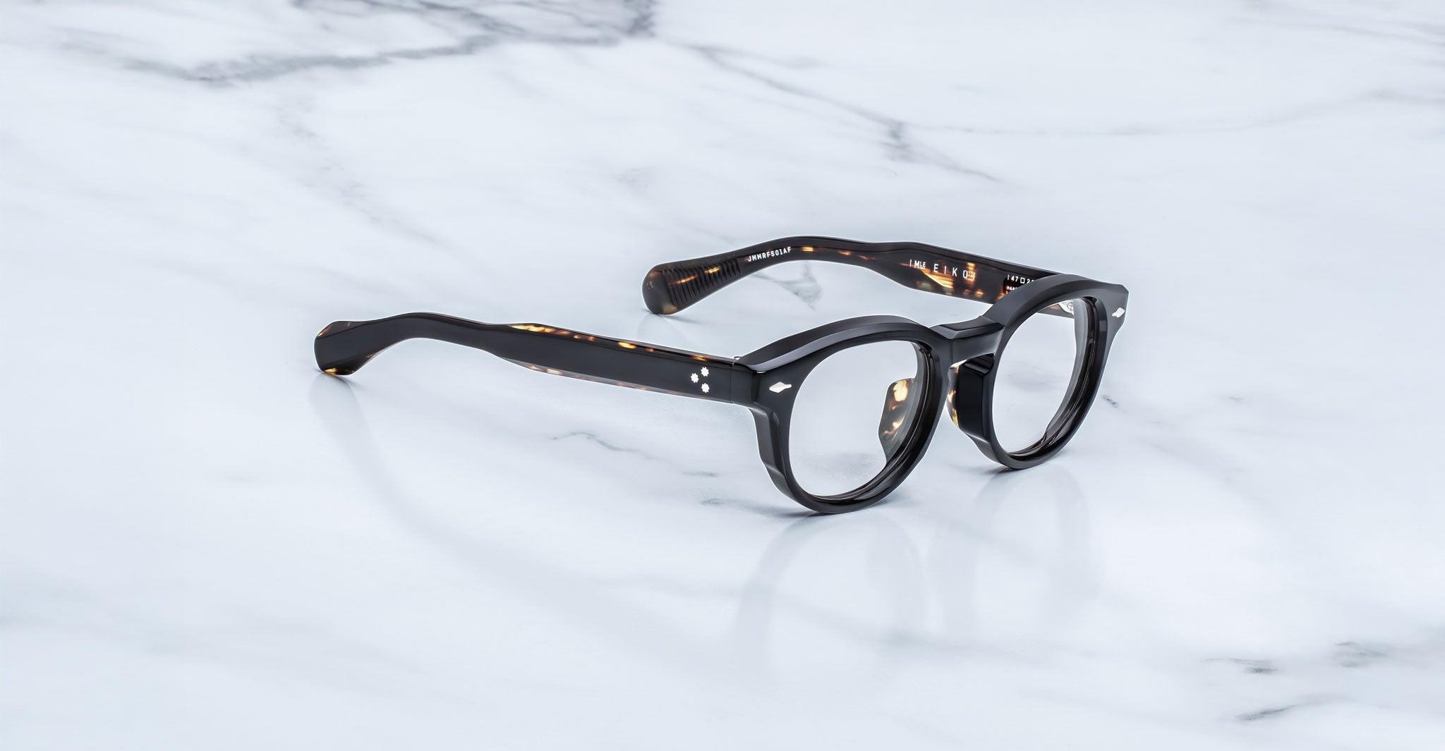 Jacques Marie Mage Eiko round black thick-rimmed eyeglasses, top view, product displayed clearly.