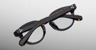 Jacques Marie Mage Eiko eyeglasses in black and tortoiseshell, shown folded from above.