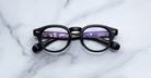 Jacques Marie Mage Eiko black round eyeglasses with anti-glare lenses, top view.