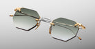 The Jacques Marie Mage El Dorado features hexagonal sunglasses with gradient gray lenses, gold and silver metal frames, and gold accents on the hinges and nose pads, shown against a light gray background.