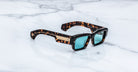 Jacques Marie Mage Engel sunglasses with blue lenses, top view, placed on a flat surface.