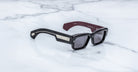 Jacques Marie Mage Engel black rectangular sunglasses with silver accents, viewed from above.