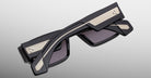 Jacques Marie Mage Engel folded black sunglasses with gold-accented arms, side view.