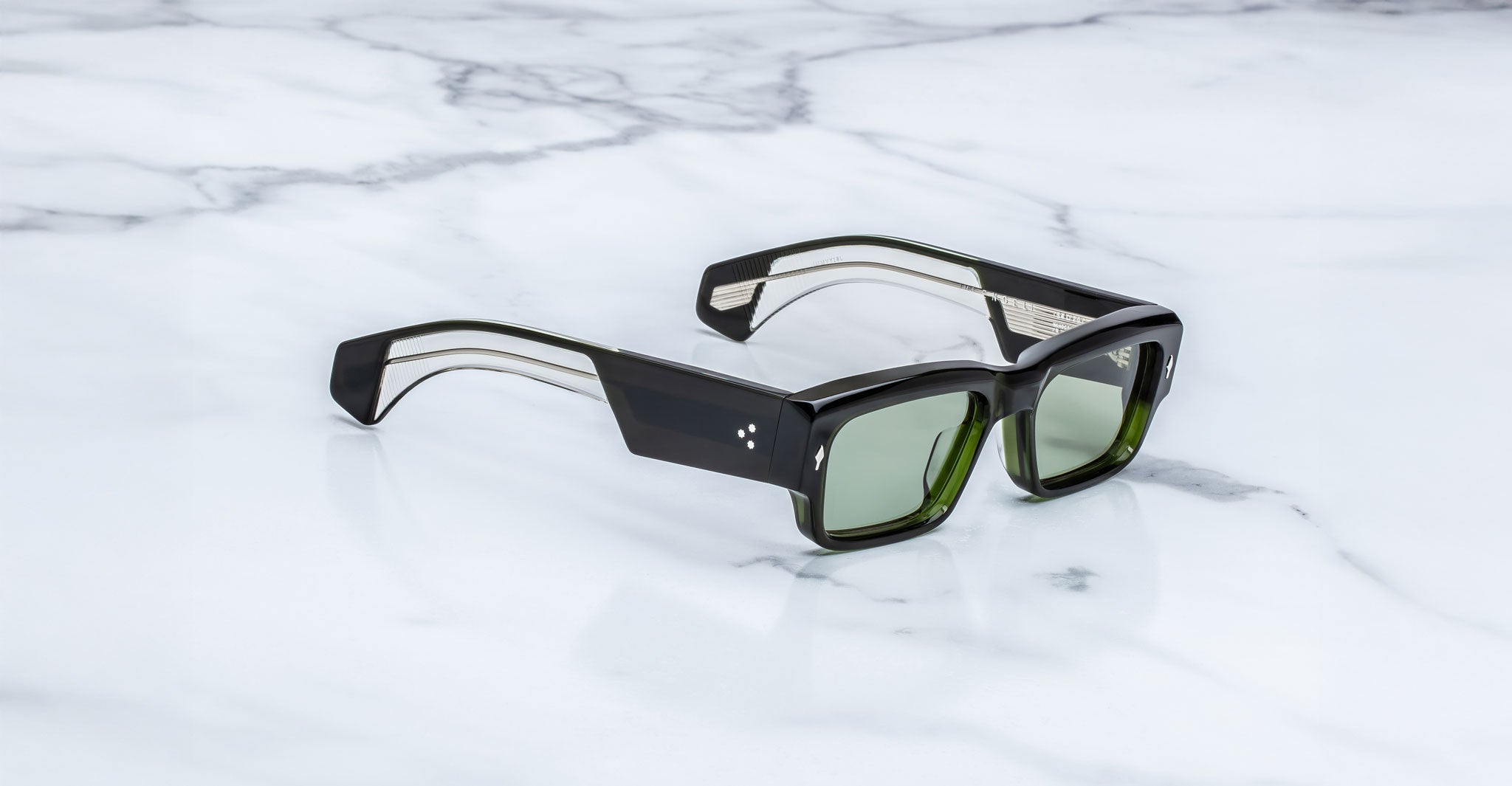 Jacques Marie Mage Engel sunglasses shown with green lenses, top-down view.