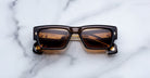 Jacques Marie Mage Engel rectangular black sunglasses with brown lenses, top view.