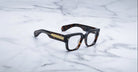 Jacques Marie Mage Enzo eyeglasses with gold-detailed arms, shown from above.
