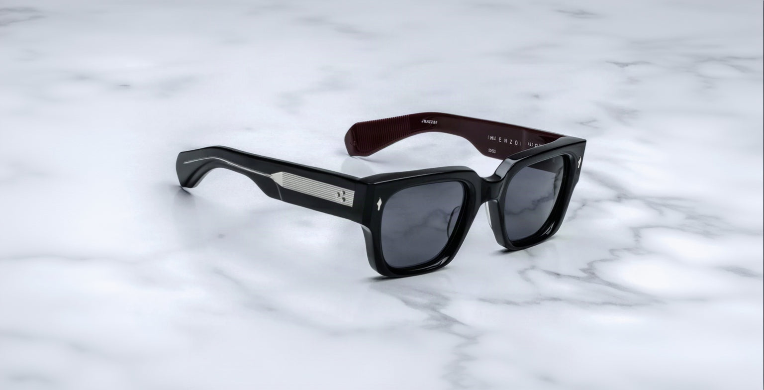 Jacques Marie Mage Enzo black rectangular sunglasses with dark lenses and silver accents, shown from above.