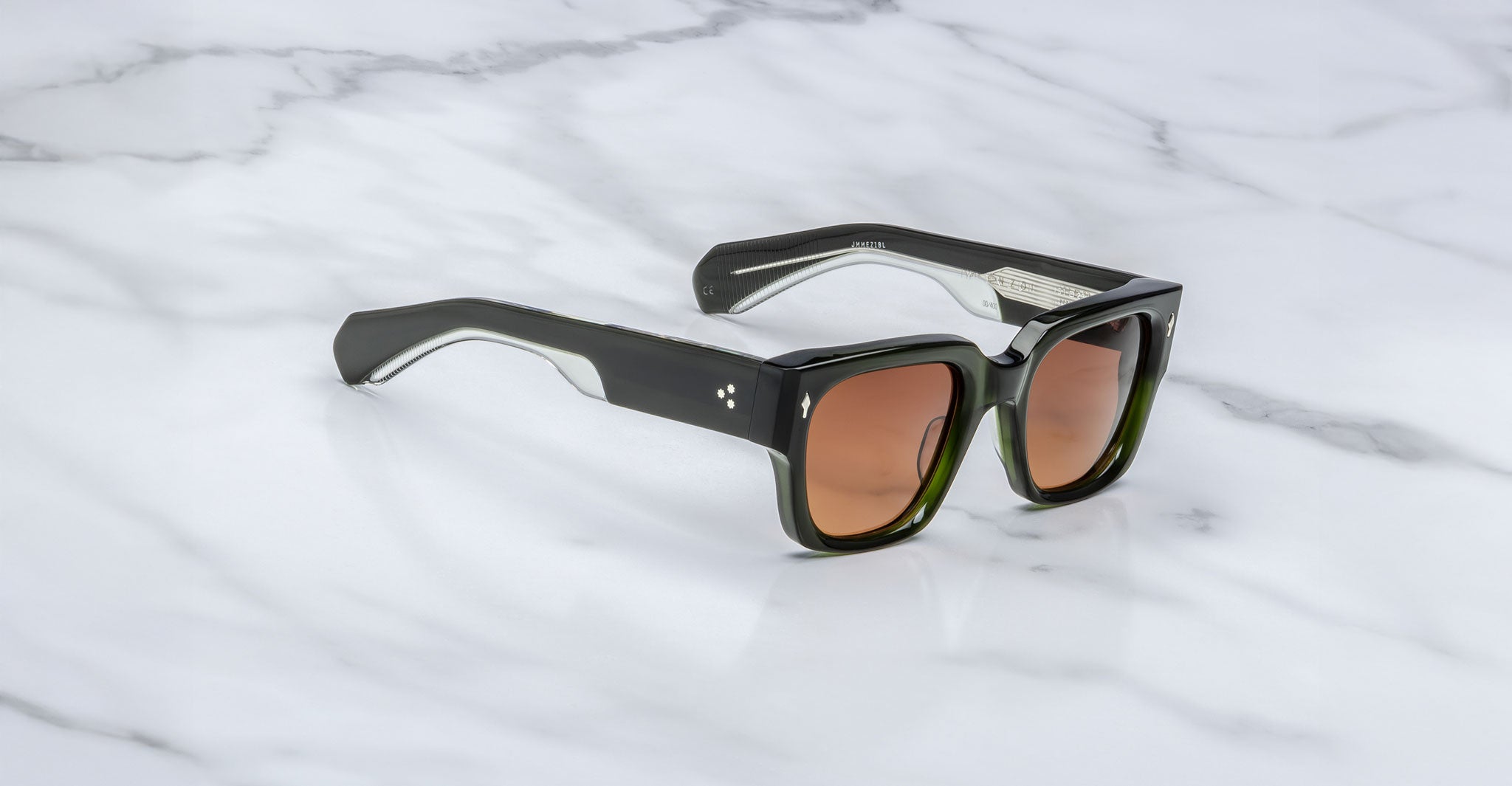 Jacques Marie Mage Enzo black rectangular sunglasses with brown-tinted lenses, viewed from above.
