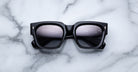 Jacques Marie Mage Enzo black rectangular sunglasses with reflective lenses, top view.