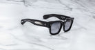 Jacques Marie Mage Enzo black rectangular sunglasses with thick frames and metallic accents, front angle view.