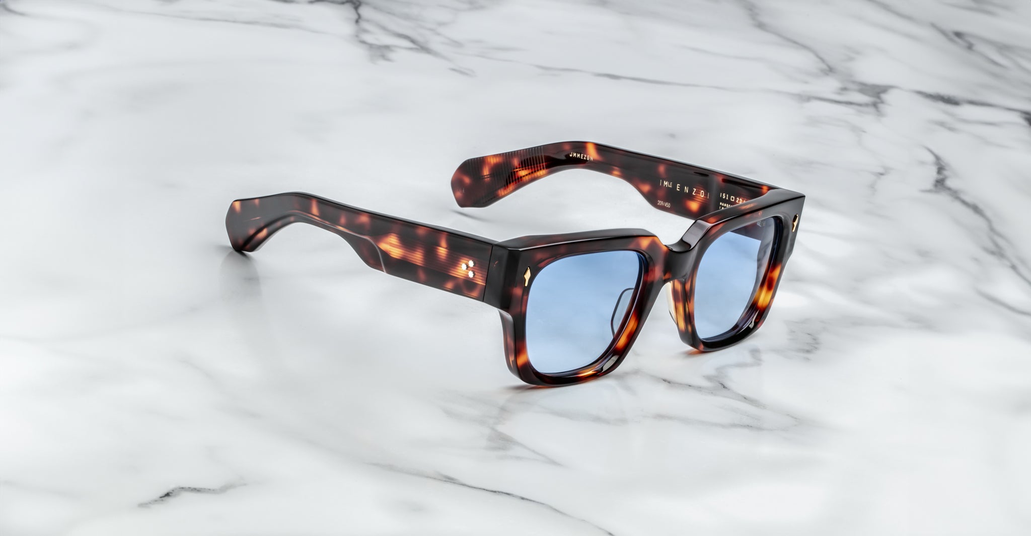Jacques Marie Mage Enzo tortoiseshell sunglasses with blue lenses, viewed from above.