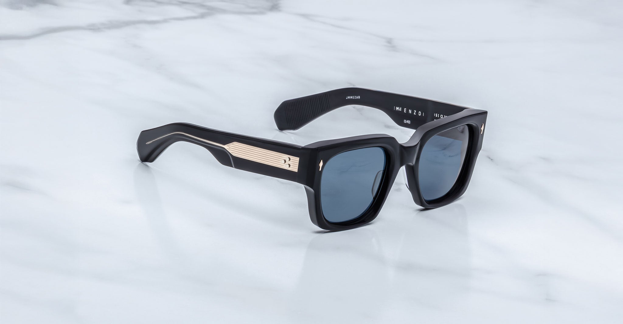 Jacques Marie Mage Enzo sunglasses, black square frame with gold accents and blue UV lenses, front view.