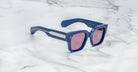 Jacques Marie Mage Enzo blue rectangular sunglasses with pink lenses and silver accents, front view.