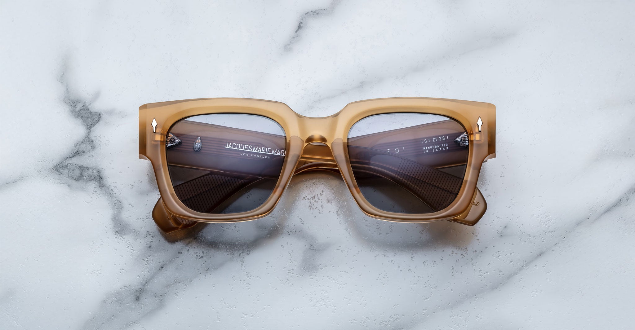 Jacques Marie Mage Enzo square sunglasses, translucent brown thick frames, top-down view.
