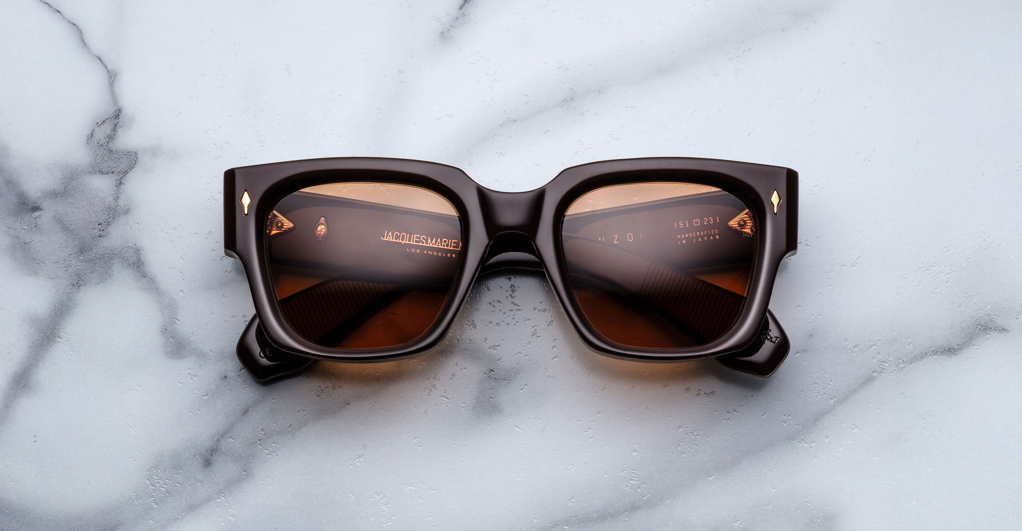 Jacques Marie Mage Enzo square sunglasses with dark lenses, top view, product on display.