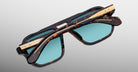 Jacques Marie Mage Evans tortoiseshell sunglasses with blue lenses and gold accents, shown from above.