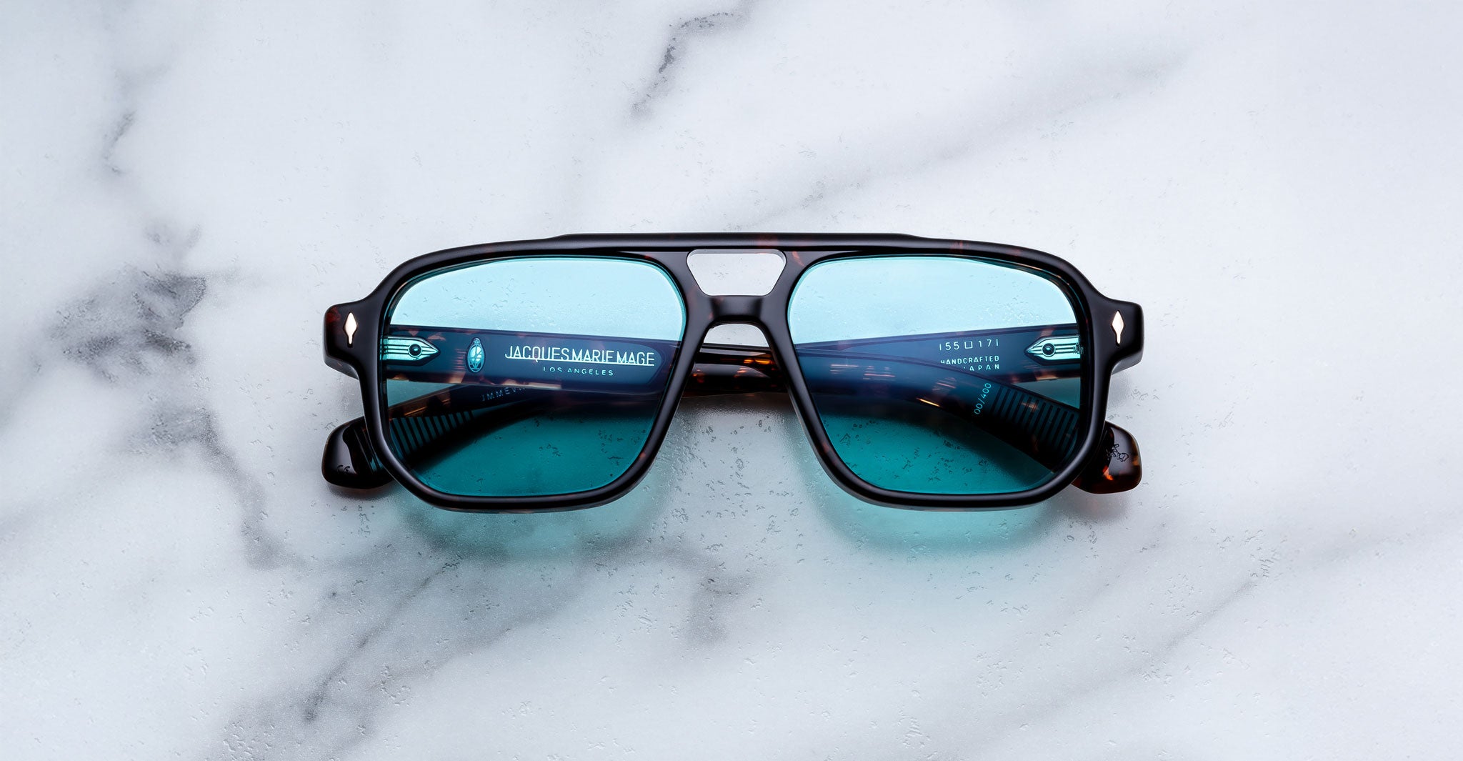 Jacques Marie Mage Evans sunglasses with blue lenses and black frames, shown from the front.