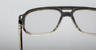 Close-up of the upper half of Jacques Marie Mage Evans optical glasses, showcasing an oversized handcrafted acetate frame against a plain grey background.