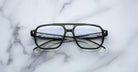 The Jacques Marie Mage Evans are black, rectangular handcrafted optical glasses with clear lenses and an oversized acetate frame by Jacques Marie Mage, displayed on a white marble surface.