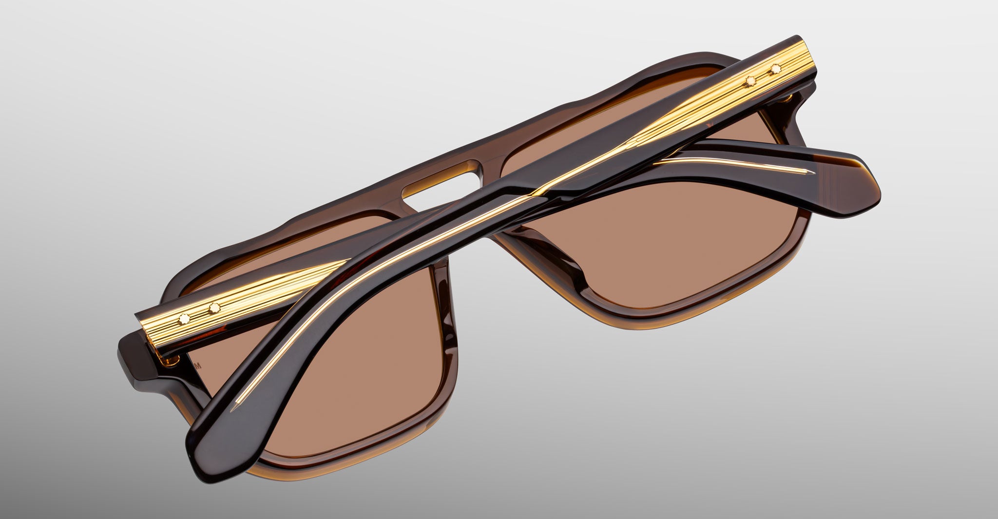 Jacques Marie Mage Evans brown and gold sunglasses, folded, top view. Model and brand name visible.
