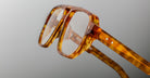 Close-up of Jacques Marie Mage Evans optical glasses showcasing a handcrafted oversized acetate frame in tortoiseshell pattern with two small white star-shaped details on the temple.