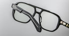 Close-up of Jacques Marie Mage Evans optical glasses showcasing an oversized acetate frame and silver temple detailing, set against a plain light gray background.