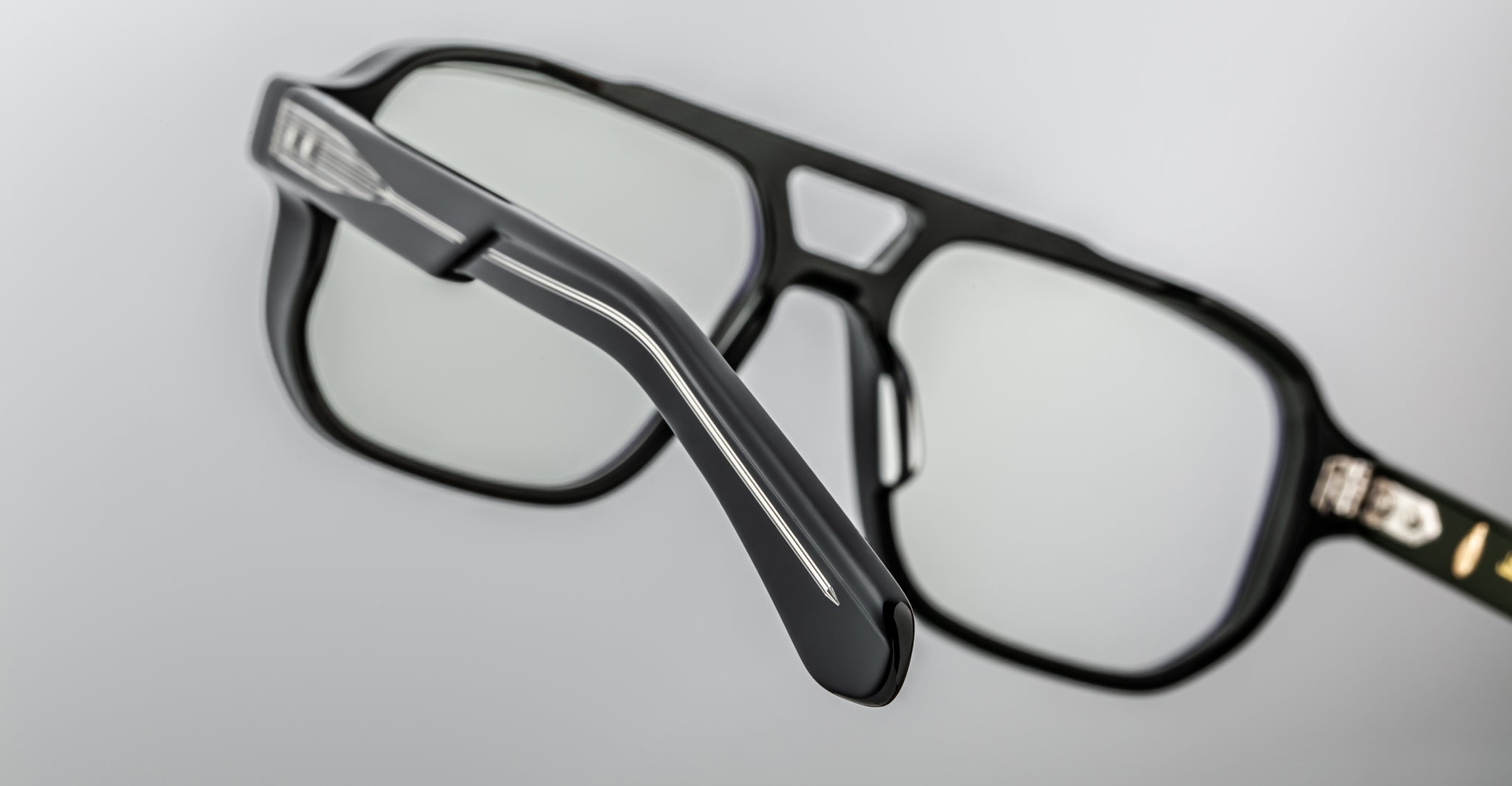 Close-up of Jacques Marie Mage Evans optical glasses showcasing an oversized acetate frame and silver temple detailing, set against a plain light gray background.
